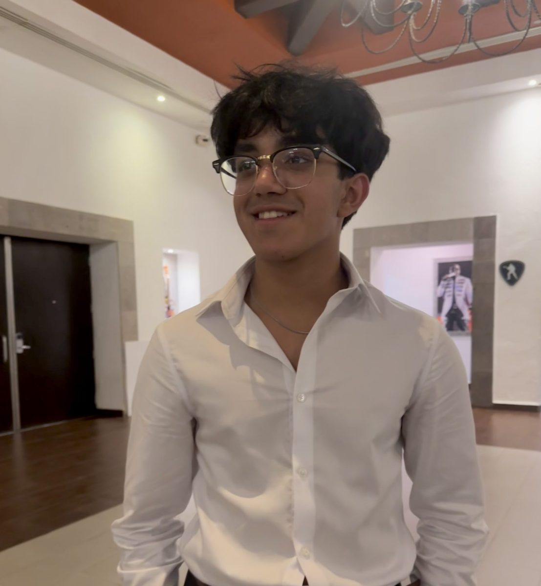 Senior Om Patel poses at a Hotel Owners Association meeting. He attends meetings with his dad to help out in behind-the-scenes work for the motel his parents own. 