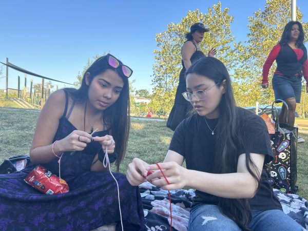 Junior Anna Burns teaches freshman Arissa Ramos how to crochet accessories for her pumpkin. Burns is the lead instructor for the Crochet and Knitting club.