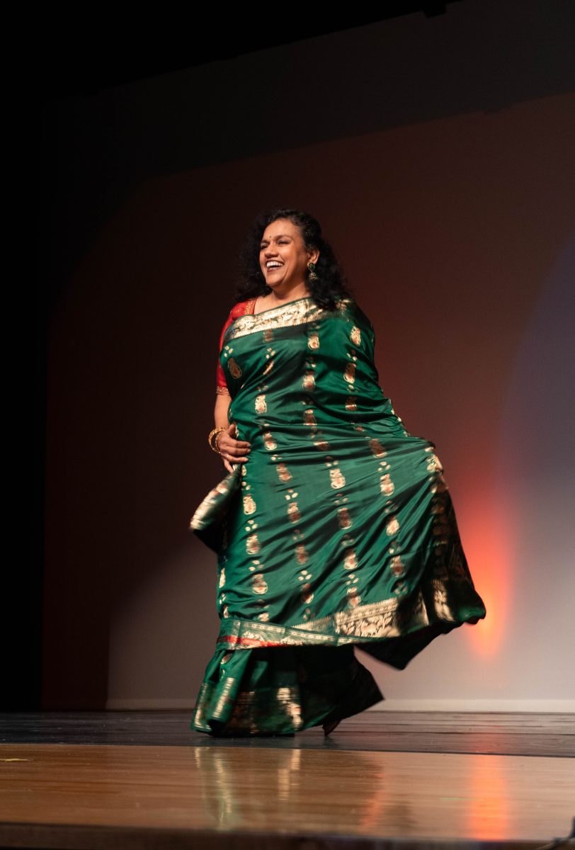 IB Astronomy, AP Physics and Independent Study Math teacher Reena Chopra poses in the fashion show to the song "Dhoom Machale." Chopra wore a traditional sari, a wrapped garment that can span up to six yards long.