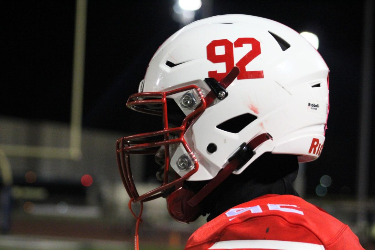 Junior Defensive End Jordan Clay watches his team from the sideline. He is waiting for his turn to return onto the field to play defense.