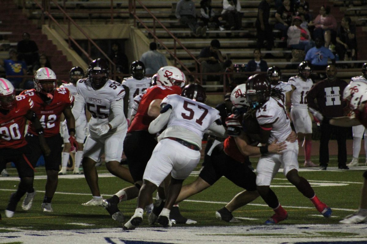 Senior defensive tackle Martin Van den bossche and senior linebacker Chris Wilson rush the quarterback. Wilson successfully wraps his arms around the quarterback getting ready to make a tackle.