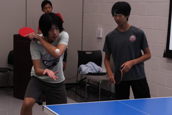 Freshman Joseph Chii serves a backhand as his partner, sophomore Nicholas Lai, watches on. "I was expecting to win because [Chii is] very good," Lai said. 