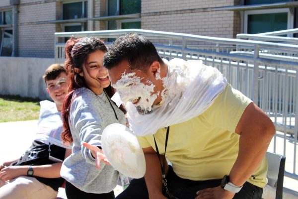 IB Standard Level Math, Algebraic Reasoning, and OnRamps Calculus teacher Johnston French watches as a student pies safety manager Oscar Lopez. He had been recently pied and waited for his next turn.