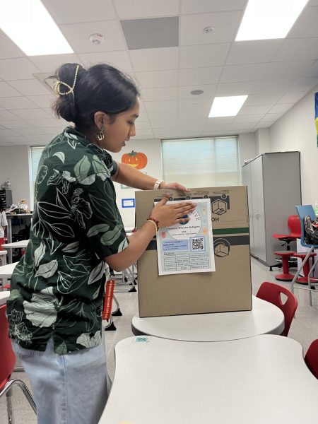 Junior Akshatha Perumal sets up a collection box for the Houston Welcomes Refugees Supply Drive. The box collected donations from Nov. 11-22. 