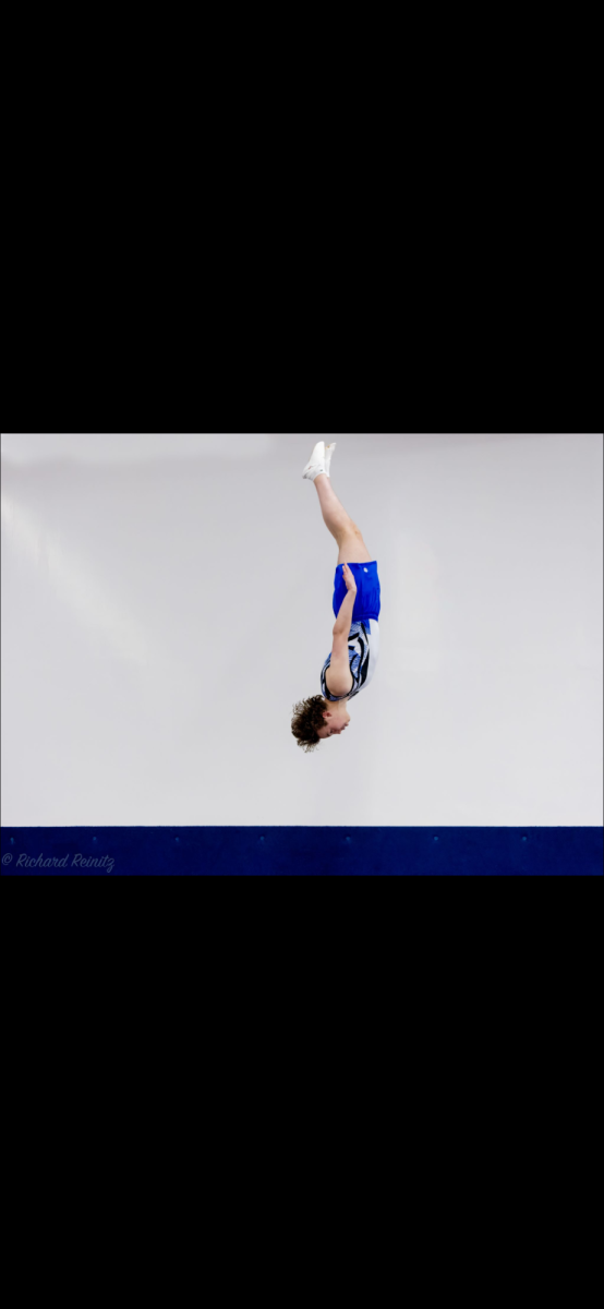 Jake practices his trampoline flips at the Houston JCC gym. He performs a front flip.