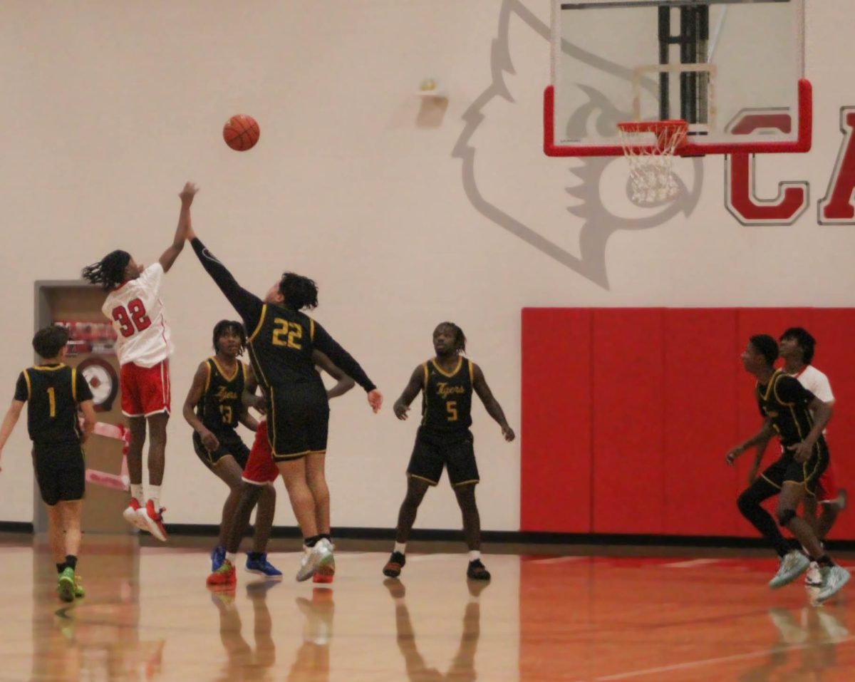 Carter Gamble sinks the perfect jump shot as the defender leaps unsuccessfully to block it.