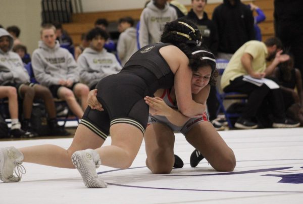 Junior Cassandra Espinosa sprawls against her opponent during her first match of the night. Episcopal High School does not have a girls' wrestling team, so the girls wrestling team only competed against opponents from Katy Jordan High School.