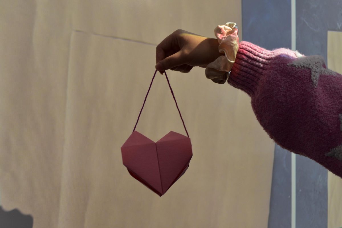 Junior and Cardinal Crafts president Serena Li finishes the final origami piece of a heart-shaped basket. She only used a few materials including paper and yarn and used glue to secure the folds and durability.