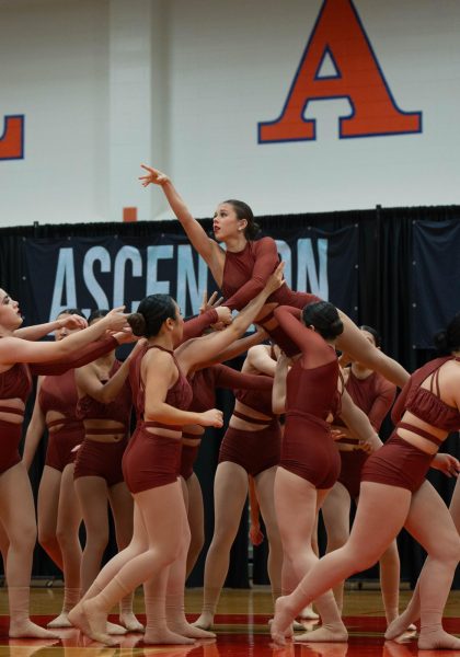 The eMotion modern dance team lifts sophomore Mia Wilner and carries her away as she reaches towards the audience. Wilner performed with the team at Ascension Dance Challenge, eMotion's first dance competition of the season, on Feb. 1.