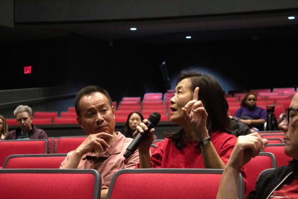 Parent Judy Cheng asks Principal Michael Niggli about false detections during the Q&A portion of the weapons detection system community meeting. The majority of the audience was made up of parents.