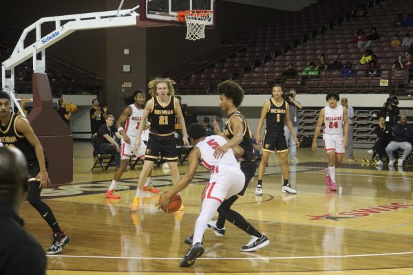 Kohlman Dutton, number 5, splits the defenders and drives to the hoop. His hard work as a point guard is displayed on court.