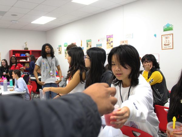 Sophomore and Tea Society president Iris Yeh hands out tea to guests. The club offered strawberry milk tea, strawberry tea and strawberry milk to attendees.