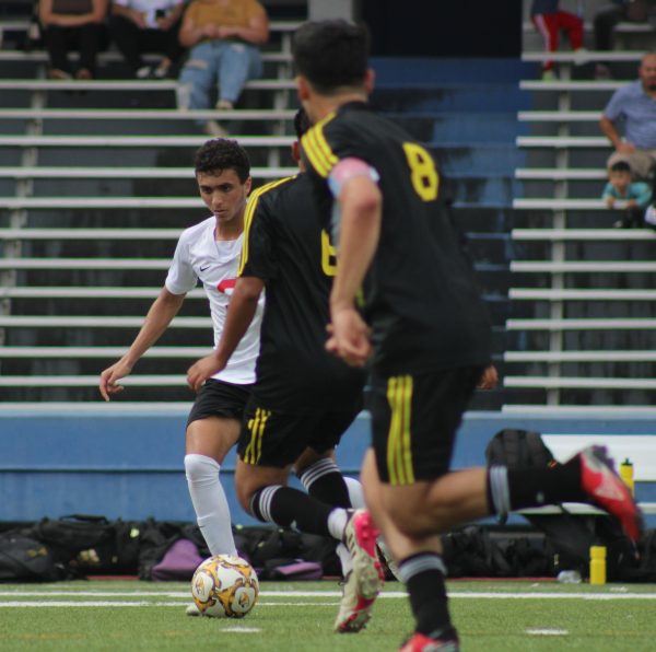 Junior Sayf Elkousy dribbles down the field avoiding the defender. Elkousy made the varsity soccer team sophomore year.