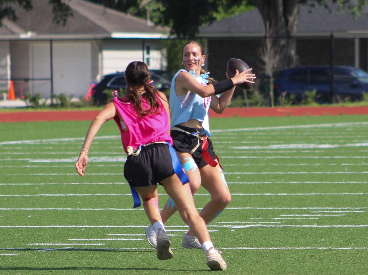 Junior Ashley Burt prepares to throw the ball as senior Sage Canahuati plays defense during the Powderpuff game on May 22. Both are members of the Bellaire varsity softball team and the Booster Club.