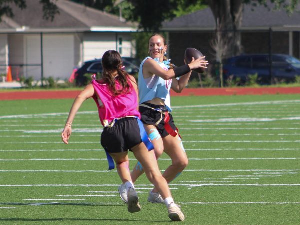 Junior Ashley Burt prepares to throw the ball as senior Sage Canahuati plays defense during the Powderpuff game on May 22. Both are members of the Bellaire varsity softball team and the Booster Club.
