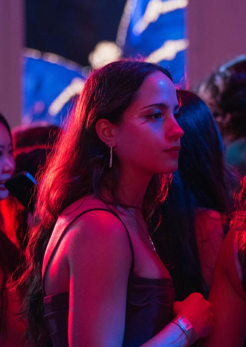 Senior Sofia Giuliani makes her way through the crowd at prom. Despite the large venue, the dance floor was filled with many people later in the night, causing space to be jammed with mingling students.