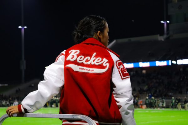 During the football playoffs, senior Olivia Becker poses for a picture. This was the first round of playoffs against Cy-Fair and her last football game.