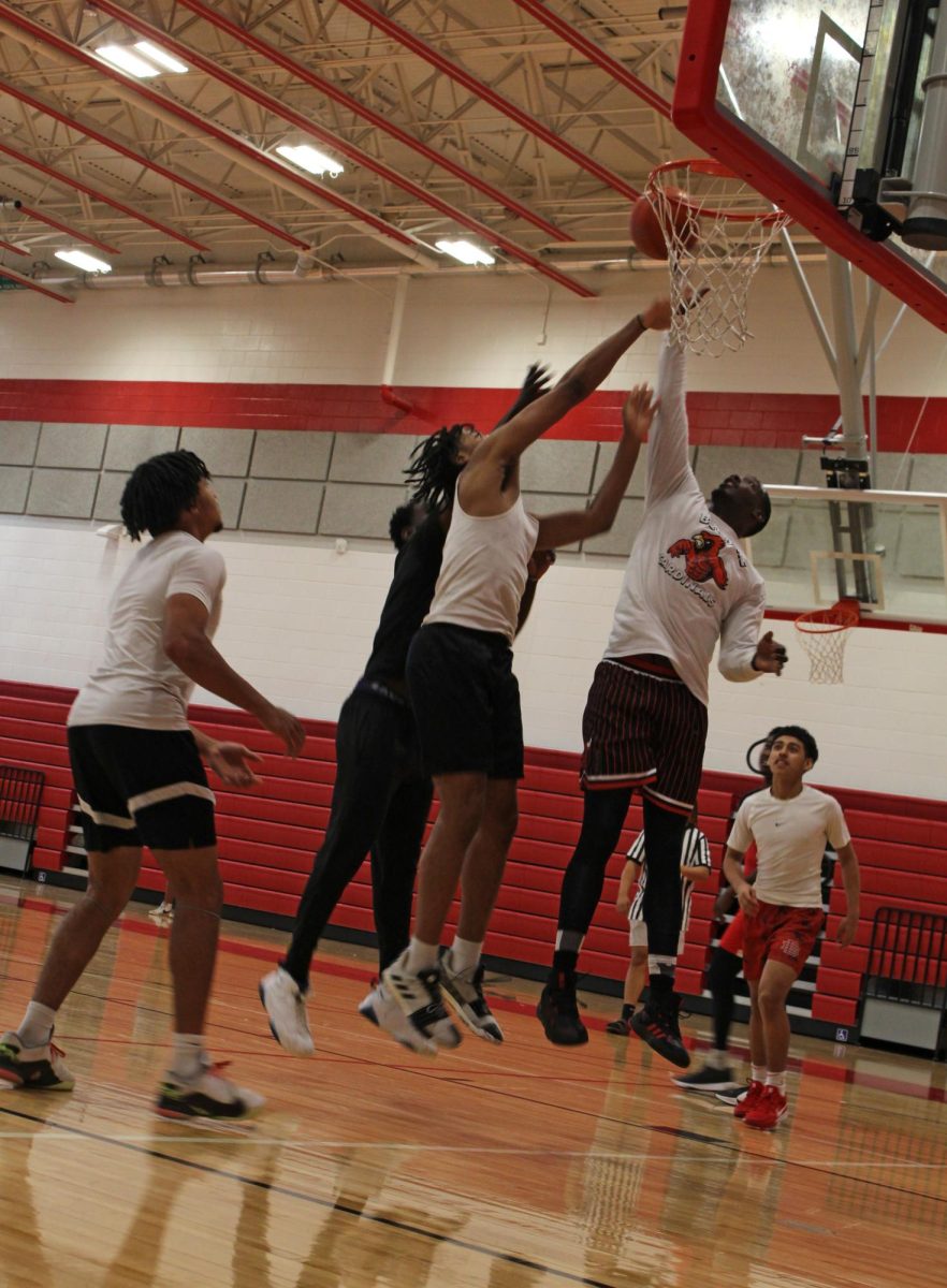 Environmental science teacher Jameal McTear attempts a layup minutes following half time. McTear is one of the few teachers and coaches to volunteer in the basketball event.