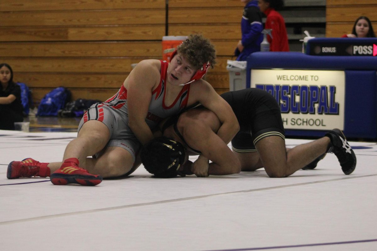 Senior Pedro Batarse looks to his coach as he tries to pin his opponent. Bellaire competed against Episcopal High School and Jordan High School at the Episcopal Tridual.