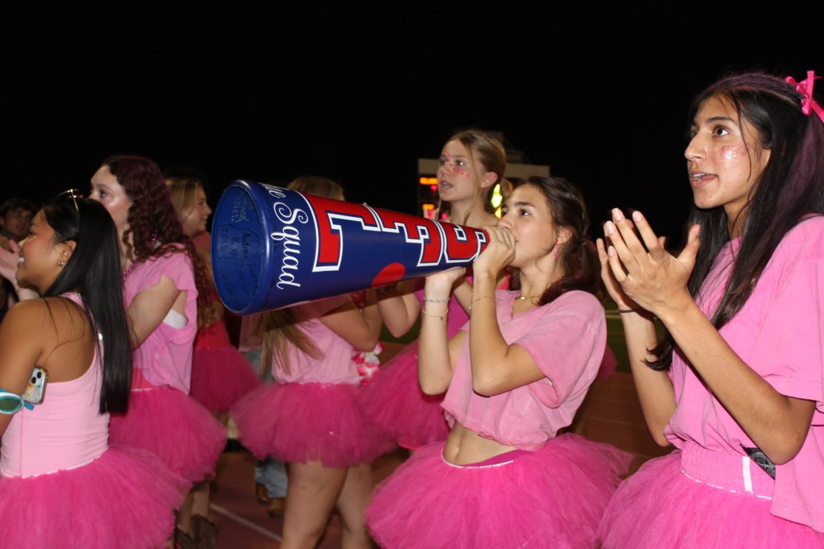 Senior and president of the boosters, Sage Canahuati uses a megaphone during a football game against Wisdom High School on Oct. 10, 2025. The theme was "pink out" for Breast Cancer Awareness Month. 