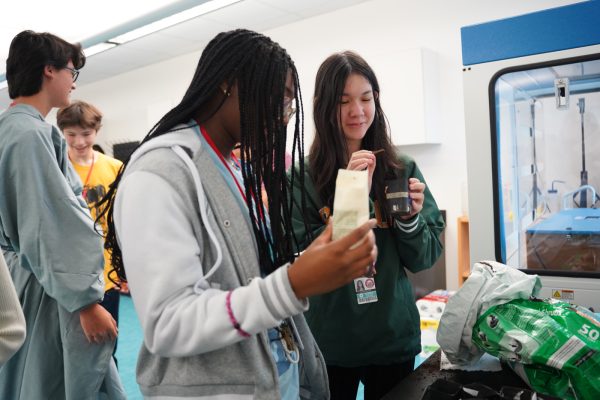 Freshmen Kirsten Damiani and DevaChristeen Dede plant their seeds into a small starter pot. This was both of their first times attending the Rooftop Garden club.