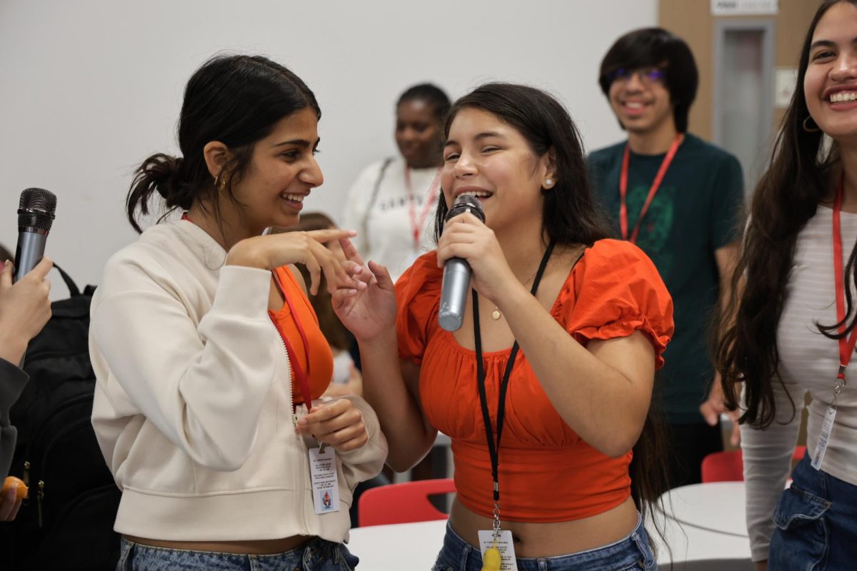 Juniors Shivali Sinha and Juliette Tannoux-Rondon sing together to a song displayed on the monitor. Karaoke Club has a meeting every Wednesday during the second half of Cardinal Hour.