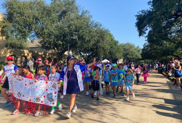 West University Elementary's third grade class marches in the Centennial parade. Senior and NHS volunteer Lela Izaddoost liked seeing her former teachers and friends while volunteering. "It's nice that something so community-making has lasted so long," Izaddoost said.