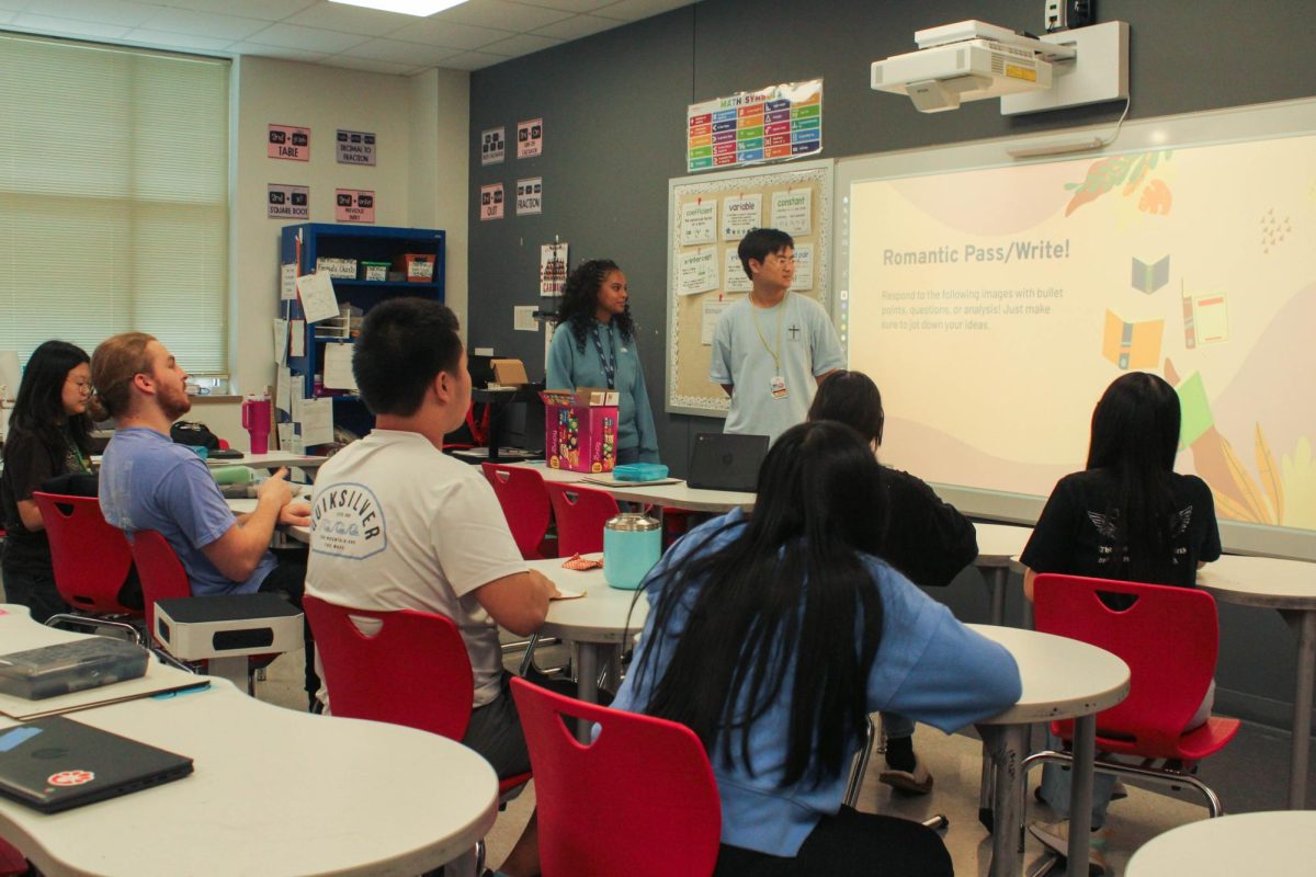 Hearts in Harmony President Bethel Kifle and W.R.I.T.E. Club President David Fang explain the Romantic discussion and quick-write activity to students. Fang was vice president of W.R.I.T.E. Club last year.