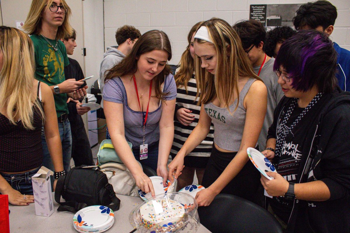 Members of the Vinyl Record Club celebrate with a birthday cake. The cake was kept a surprise from Krane, and was revealed to have been signed by her close friends.