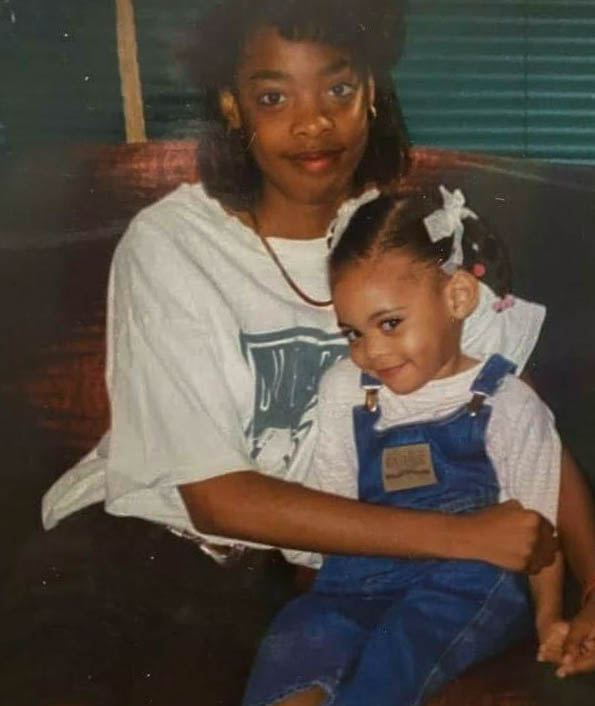 College Access Coordinator Jasmine Thomas sits with her older sister on the couch. Thomas and her sister are ten years apart, but "extremely close."