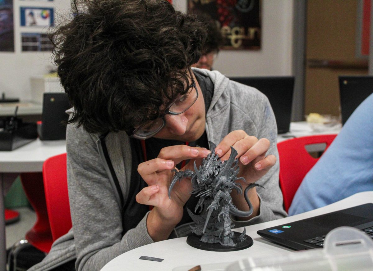 Sophomore Charles Hudlow works on creating his minifigure for the Warhammer Alliance.