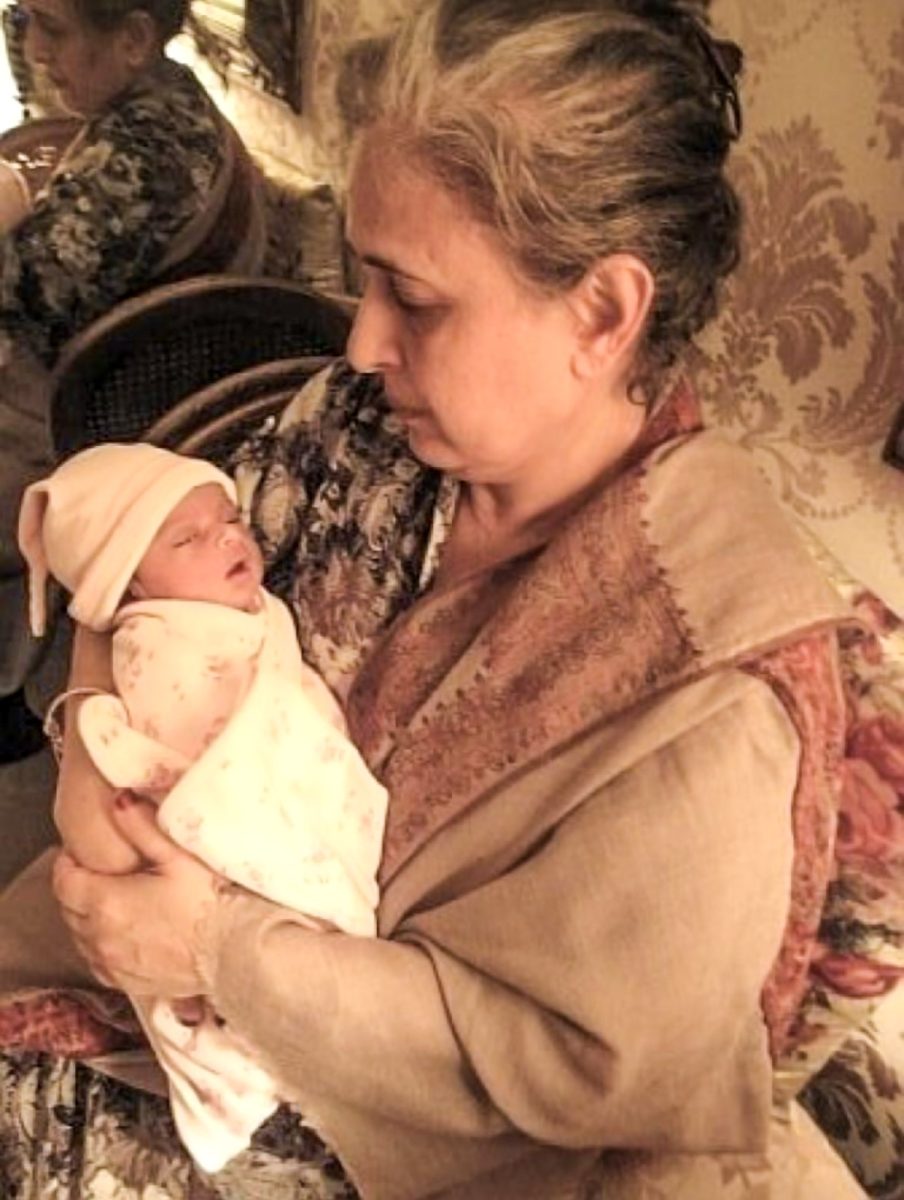 My maternal grandmother holds me as an infant in her arms. She passed away when I was three in 2012.
