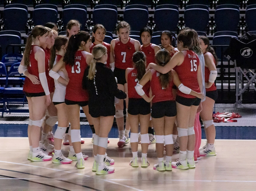 The Lady Cardinals huddle after the second set. The Cardinals dominated set two 25-13.