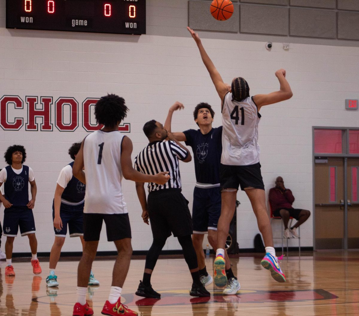 Junior center Brian Scott jumps for the ball in the beginning tipoff of the game. The Bellaire boys varsity basketball team competed in the Bellaire Shootout basketball event on Nov. 8. 