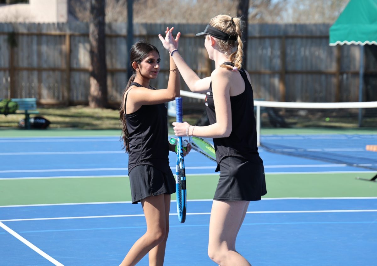 Sophomore Miki Krishnan and junior Mia Evans celebrate after winning a point in their first doubles match of the day. The tournament was their second time competing in doubles together.