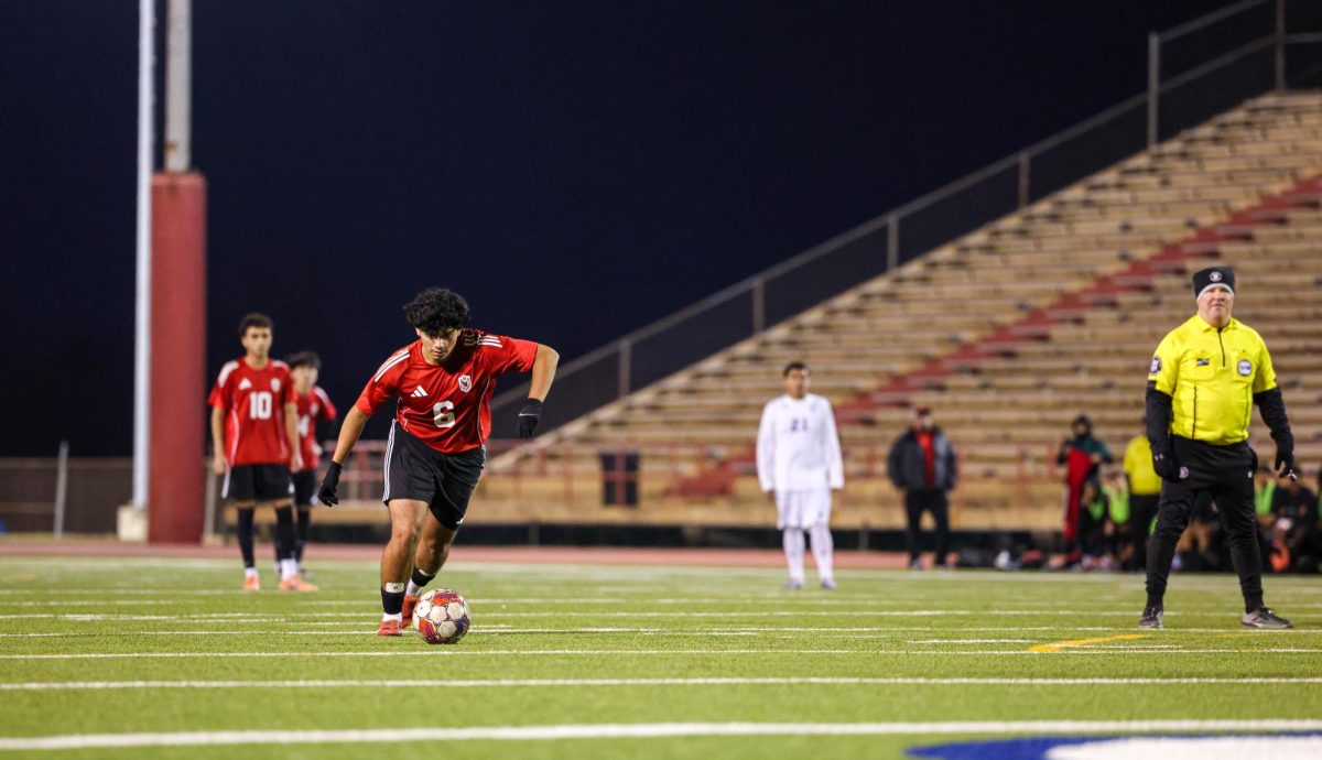 Senior Arturo Garcia kicks the ball down the field. Garcia plays center defensive midfielder.