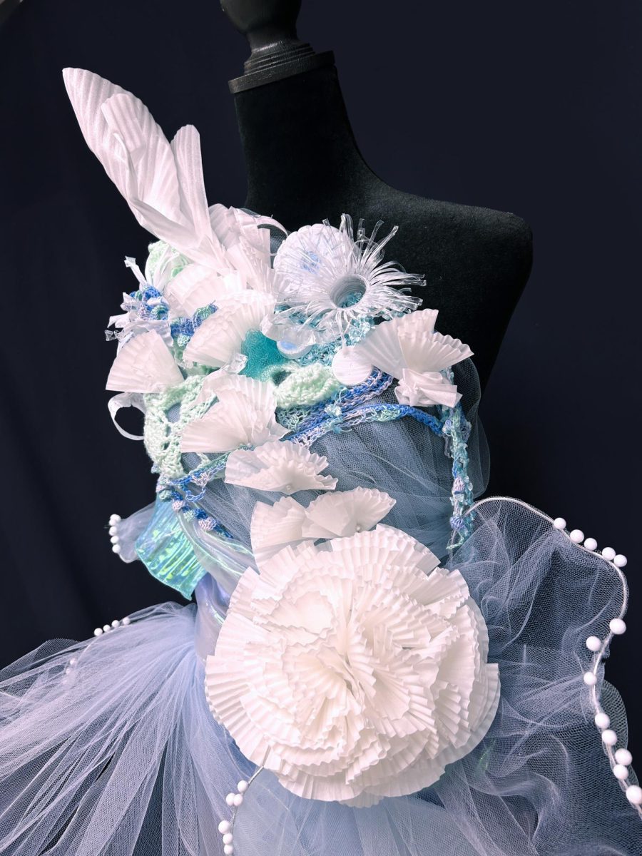 Zheng uses crocheted yarn, folded paper, mesh, and plastic bottles within her piece. She went through many variations of the design before she decided on the final dress.