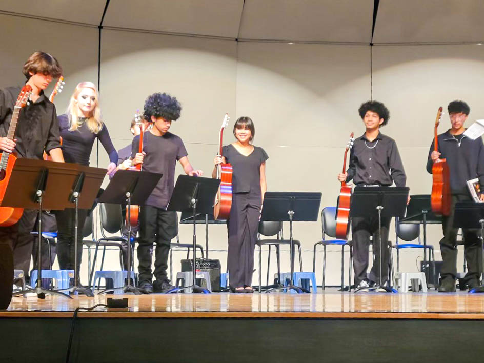Sasha Romero stands on stage with her guitar classmates at the Bellaire guitar concert in December. The ensemble bowed at the end of the show as the audience applauded.