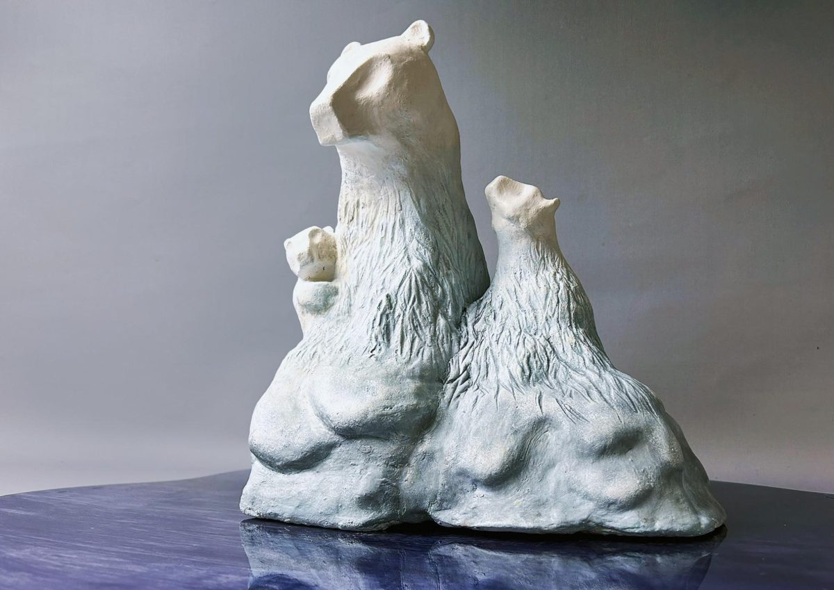Three polar bears are huddled together on a melting iceberg. The piece was titled “Meltdown.”
