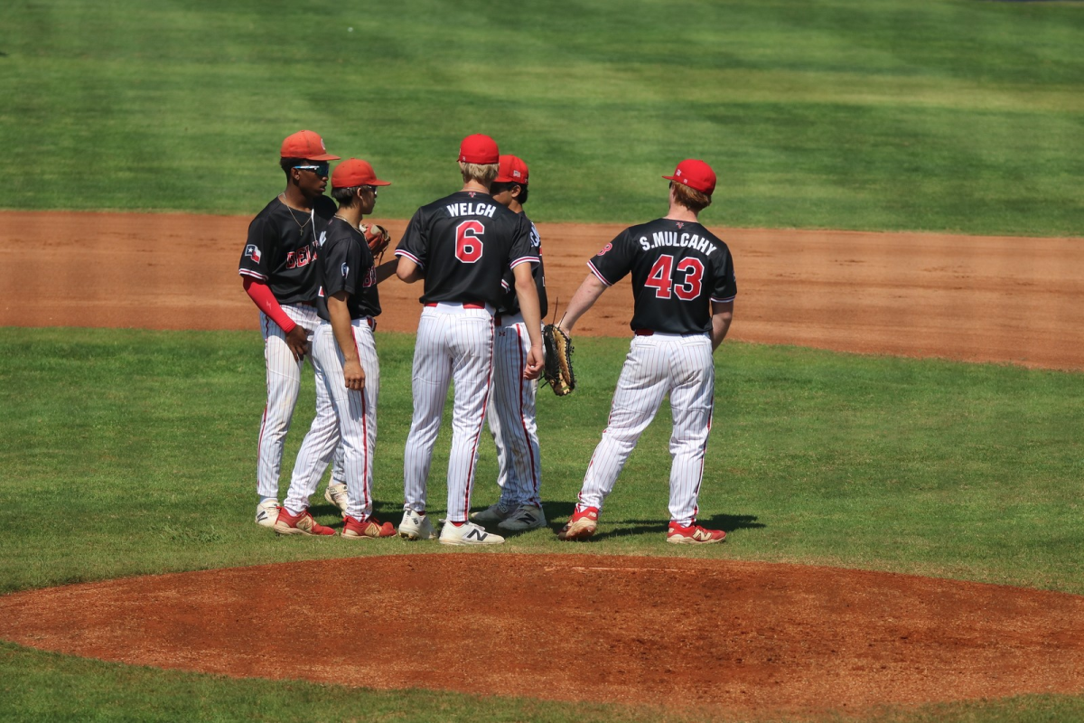 Junior first baseman Sullivan Mulcahy and sophomore third baseman Connor Welsh meet at the mound Feb. 16 at St. Thomas High School to discuss their defensive plan. The game marked the first official matchup of the season. Coach Ozuna said, “Defense is one of the biggest things we are working on.”