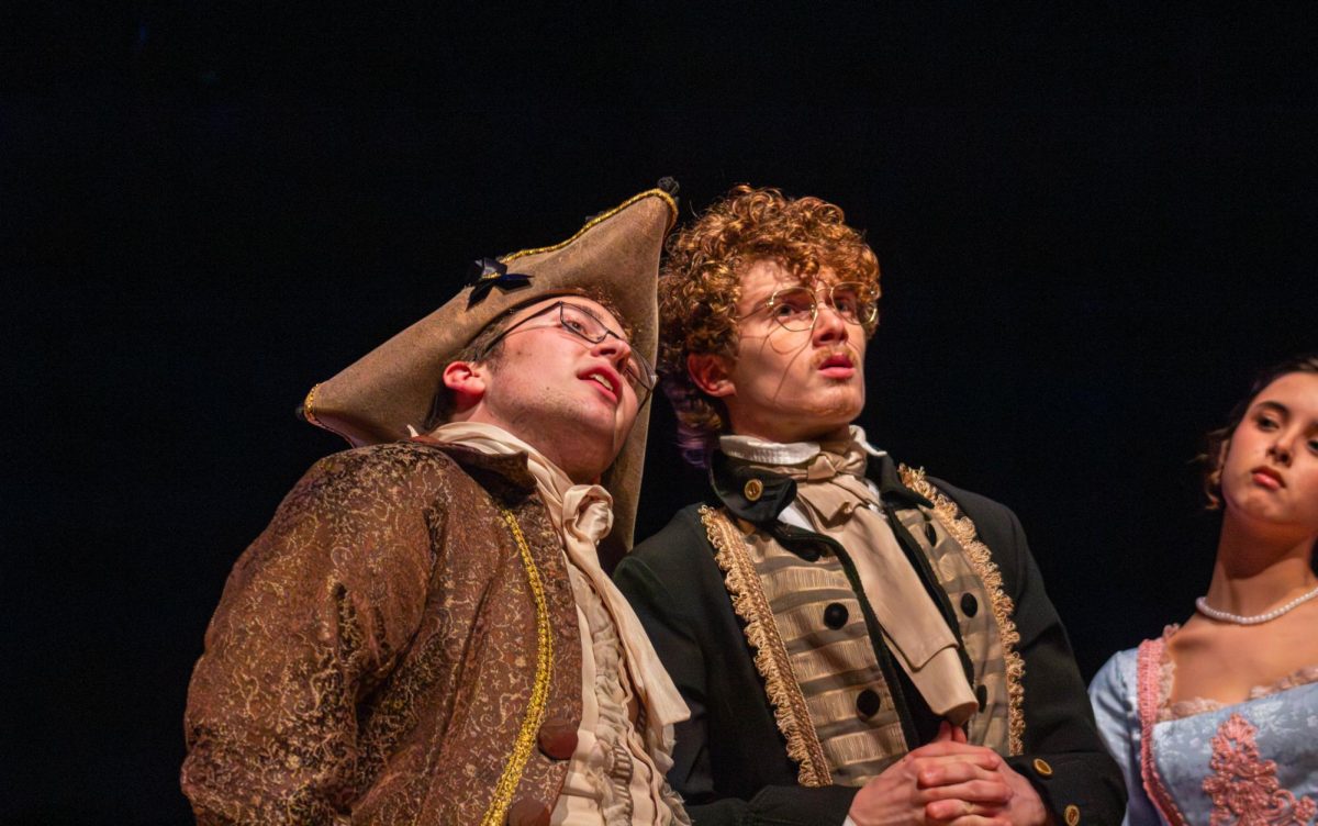 Baltus Van Tassel, played by junior Davis Adams, describes to senior Aiden Gross in the role of Ichabod Crane the haunting past which the town holds. Tassel told Crane about the German spirit who was killed at a tree down the path to his house and now haunted the town.