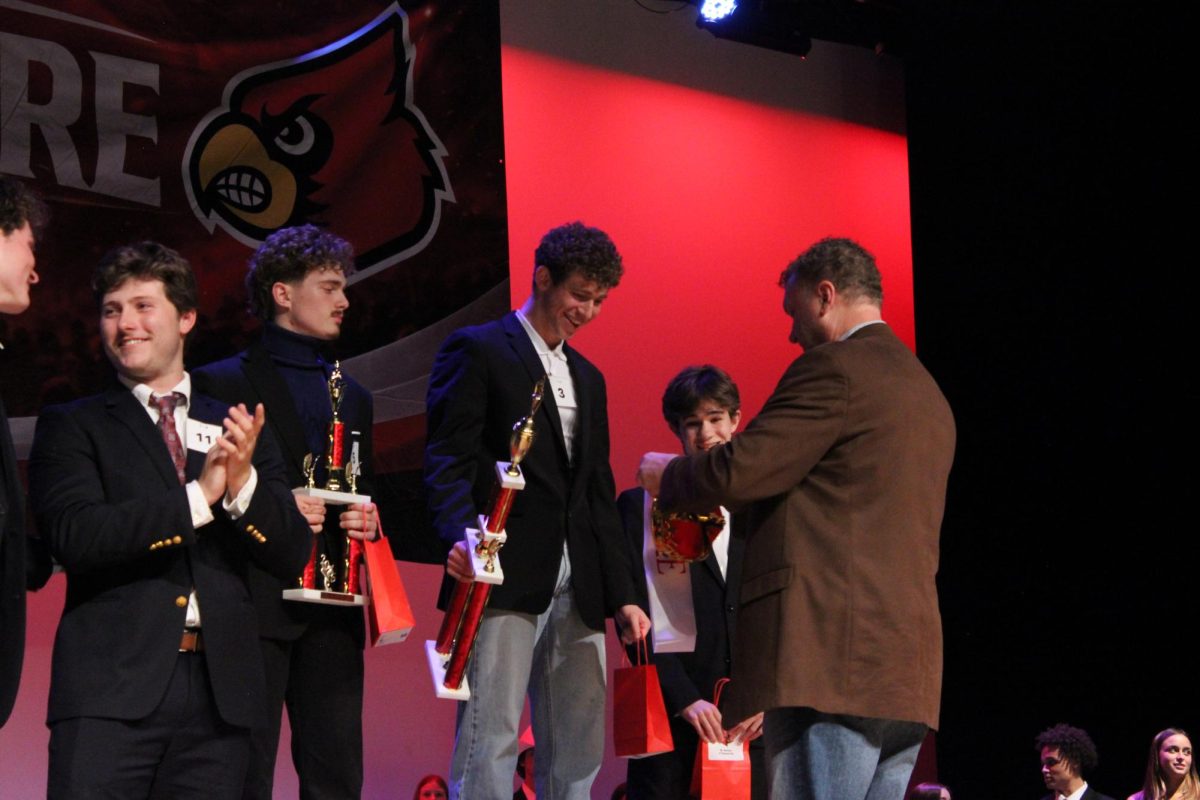 Seniors and Mr. Bellaire contestants Aiden Gross, David Raichman and Jay Krane are presented awards for coming in the top three of the contest. Principal Michael Niggli presented Raichman, Mr. Bellaire winner, with his award.