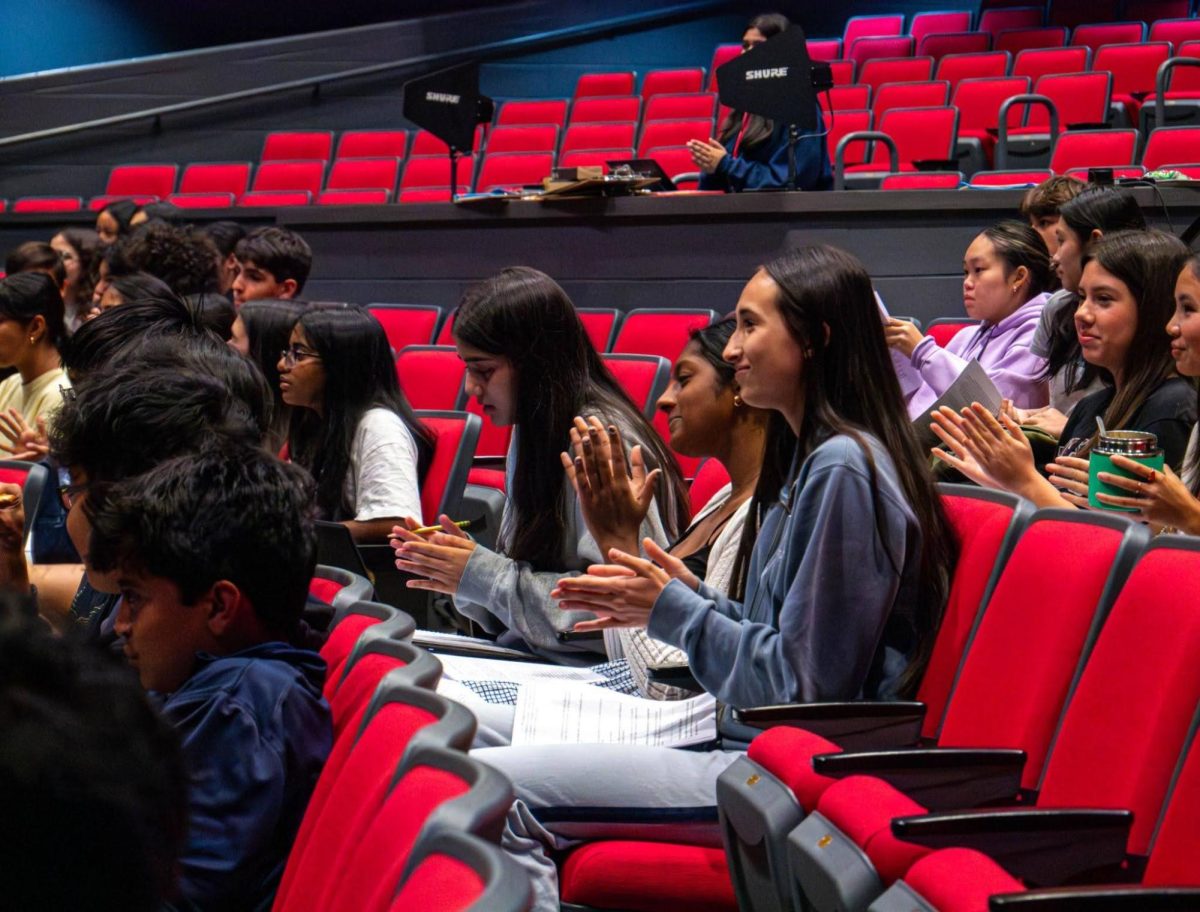 Junior Olivia Wang and sophomores Seetha Venkatachalam and Mariam Sheikh clap at the end of a question segment. Some questions asked pertained to essays, extracurricular activities and the impact of GPAs. 