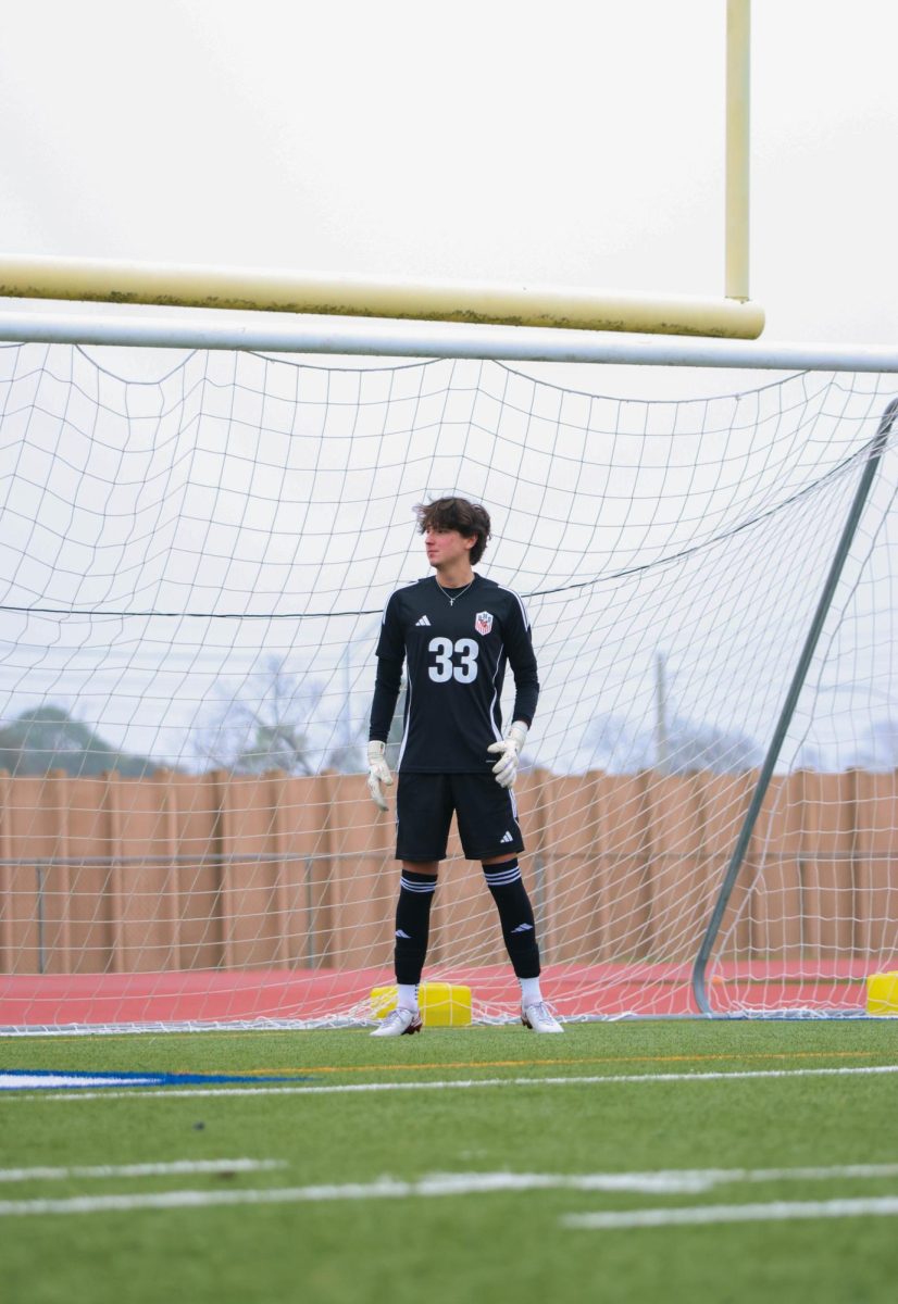 David Luigi Camerlo warms up for the team’s Senior Day game against Heights High School. The match ended with a draw, but Camerlo saved two penalties in a row to win the game.