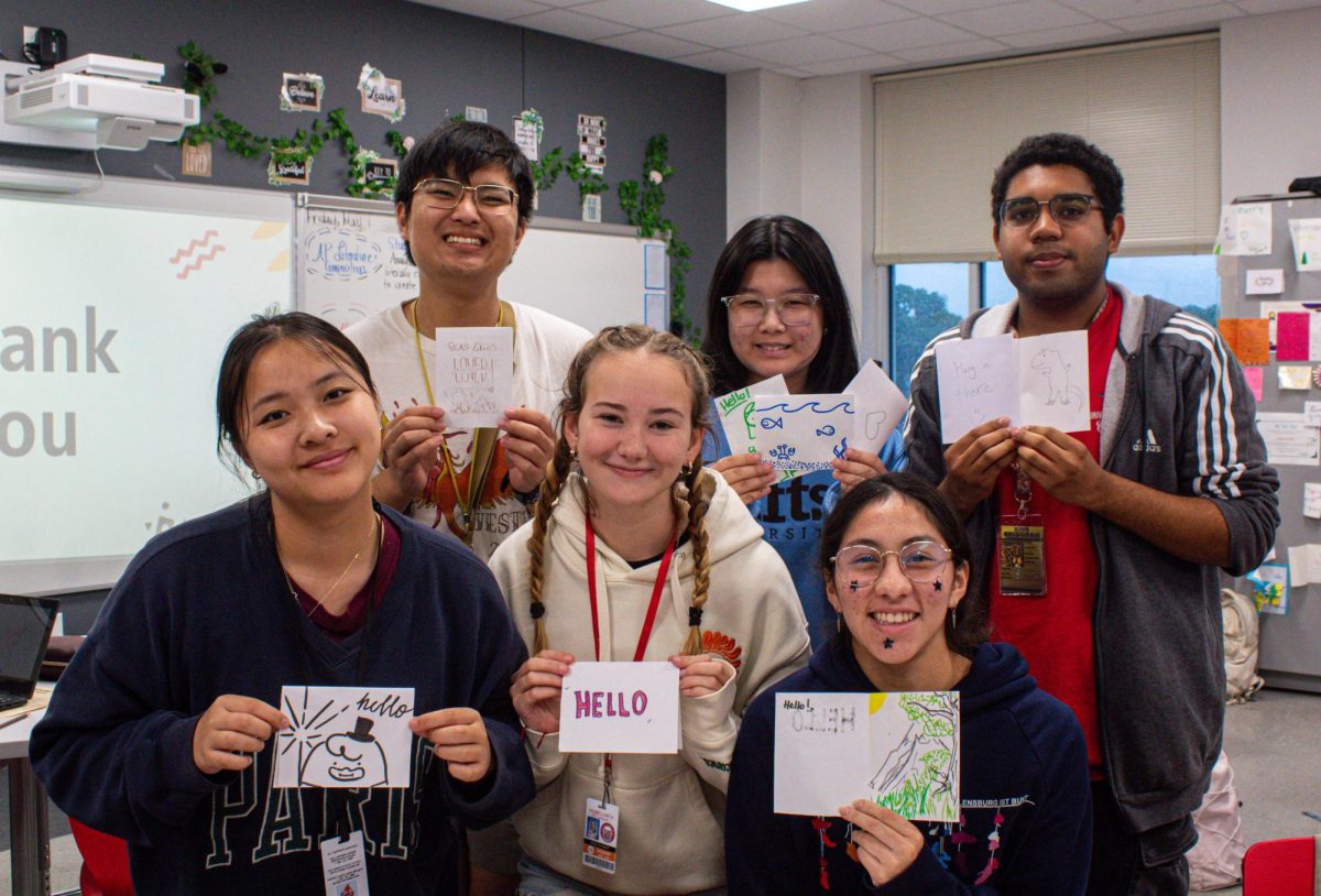 Members of Mock Trial Club hold up their letters of encouragement that will be delivered to prison inmates. A total of 19 letters were written and will be delivered via mail.
