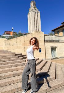 Senior Abigail Brams makes the “Hook ‘em Horns” hand gesture representing The University of Texas at Austin’s Texas Longhorn mascot. Brams visited the school for an event for recently admitted students.