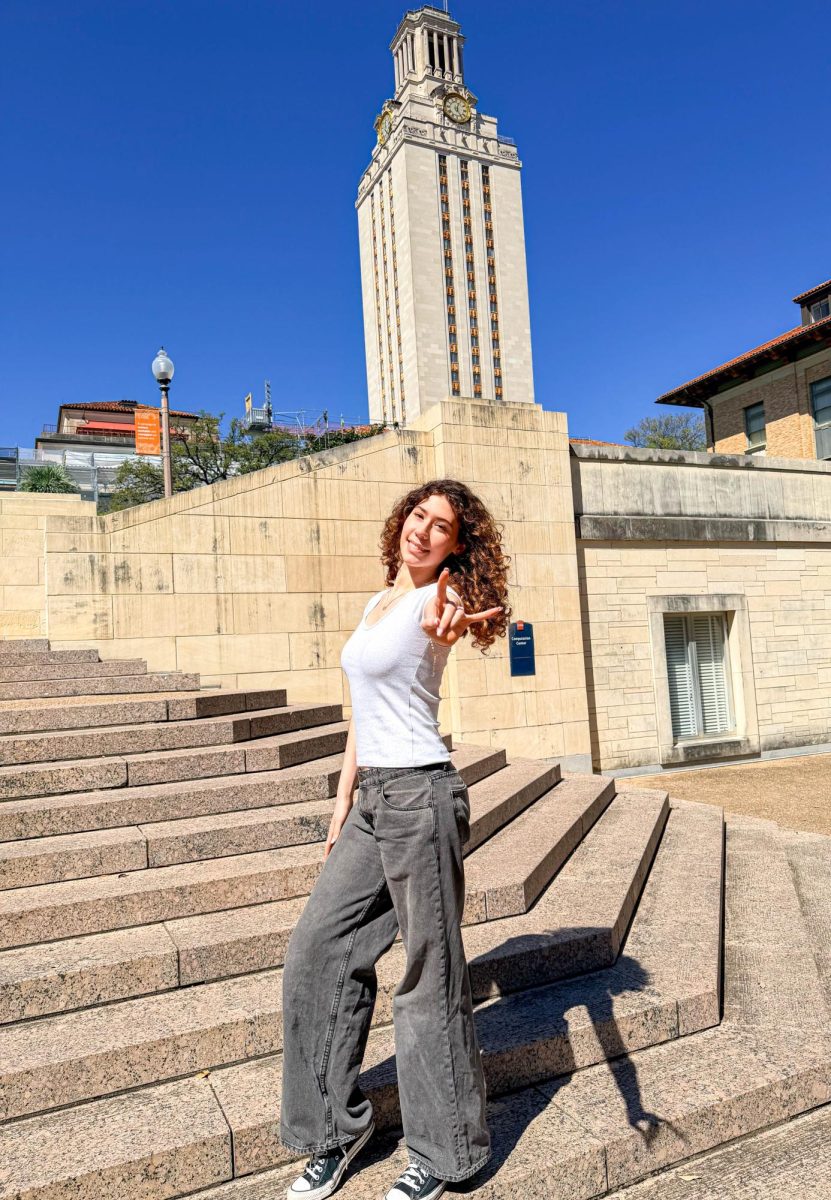 Senior Abigail Brams makes the “Hook ‘em Horns” hand gesture representing The University of Texas at Austin’s Texas Longhorn mascot. Brams visited the school for an event for recently admitted students.