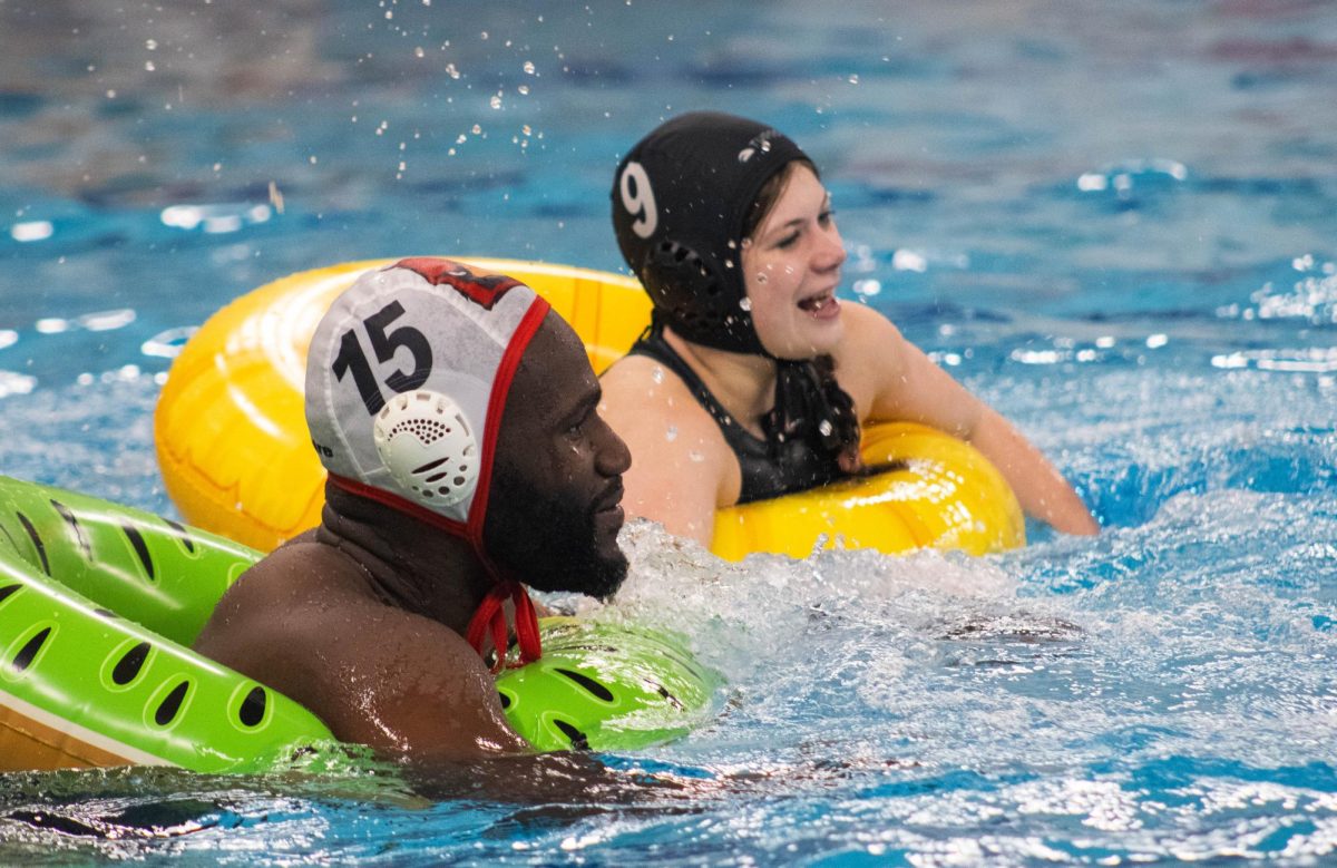 On-Level Chemistry teacher Akintunde Odunleye floats side by side in the pool with a student. Coach O's team fell short to the students at the end of the fourth quarter.