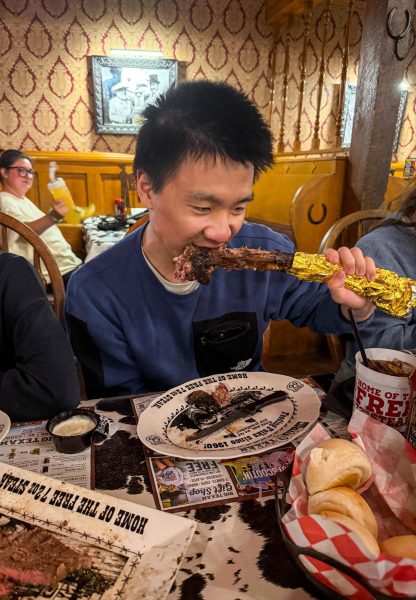 Senior Jeffrey Guo gnaws on the bone of a tomahawk steak at Big Texan Steak Ranch. This was his first “Texan meal” in America and thought it was “definitely delicious”.