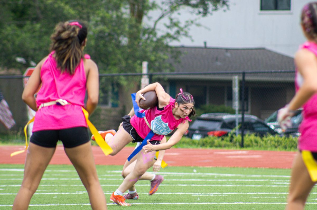 Senior Laila Hakki runs past junior defenders. Hakki also played in the Powderpuff game last year as a junior.